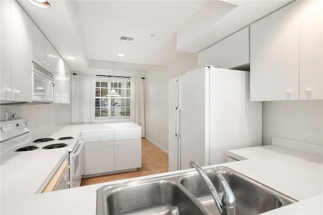 5540 N Harbor Village Dr Unit 103, Vero Beach, FL 32967 - kitchen featuring white cabinets, white appliances, light countertops, and a sink