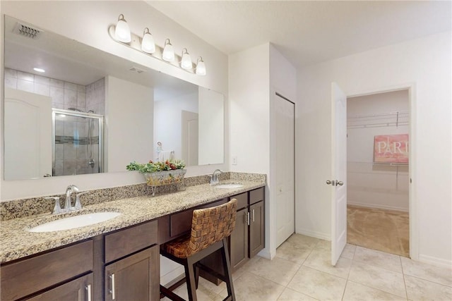 9036 103rd Ave, Vero Beach, FL 32967 - full bath featuring a shower stall, double vanity, tile patterned floors, and a spacious closet
