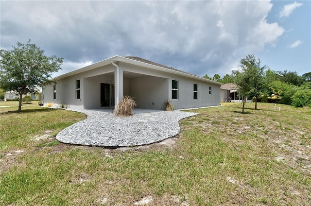 9036 103rd Ave, Vero Beach, FL 32967 - back of house with stucco siding, a lawn, and a patio