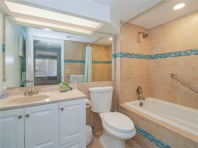 full bathroom featuring tile walls, vanity, toilet, tile patterned flooring, and shower / tub combo with curtain