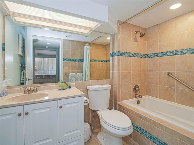 1850 Bay Rd Unit 3G, Vero Beach, FL 32963 - ensuite bathroom featuring tiled shower / bath, tile walls, vanity, and tile patterned floors