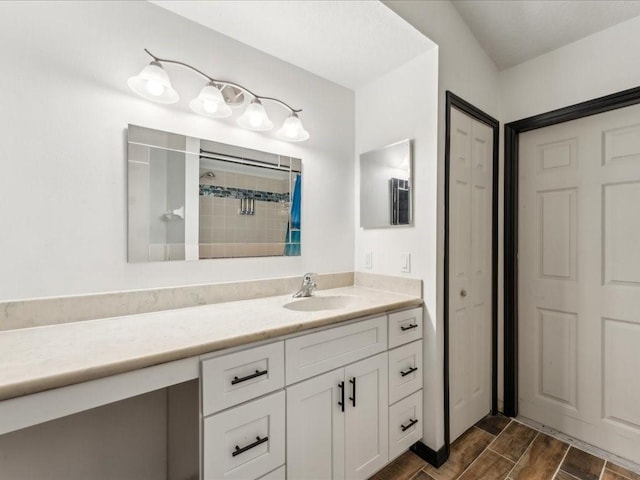 bathroom featuring vanity, wood finished floors, tiled shower, and a closet