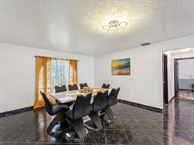 dining space with baseboards and a textured ceiling