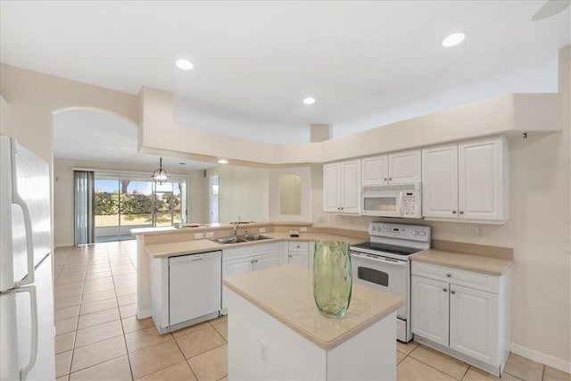413 W Tangerine Sq SW, Vero Beach, FL 32968 - kitchen with white appliances, a peninsula, light countertops, white cabinets, and a center island
