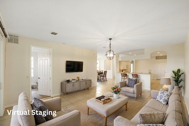 413 W Tangerine Sq SW, Vero Beach, FL 32968 - unfurnished living room featuring a chandelier and light tile patterned floors