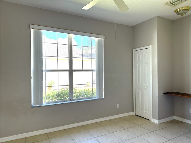 unfurnished room with ceiling fan and light tile patterned floors