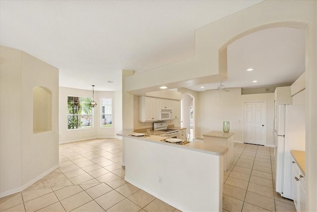 413 W Tangerine Sq SW, Vero Beach, FL 32968 - kitchen with white appliances, arched walkways, light tile patterned flooring, white cabinetry, and a ceiling fan