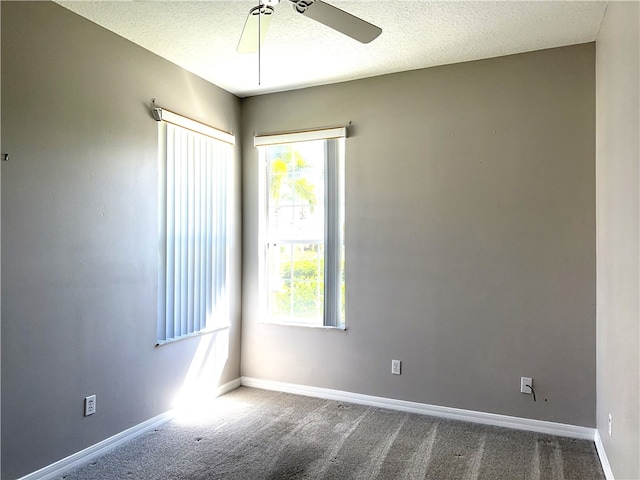 carpeted spare room with a textured ceiling and ceiling fan