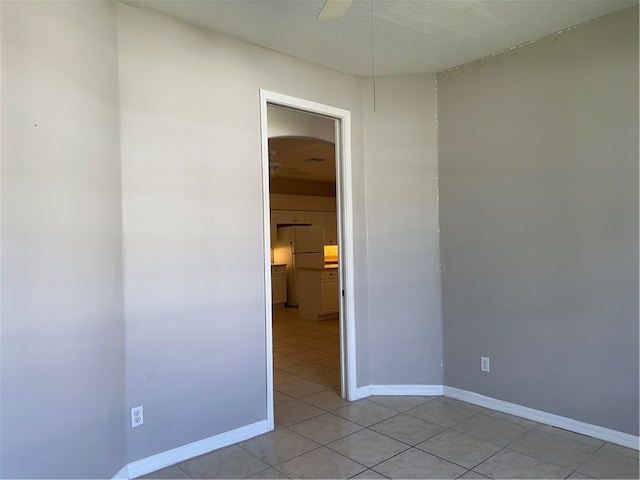 unfurnished room with a textured ceiling and light tile patterned floors