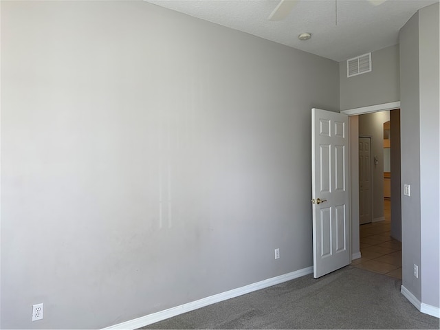 carpeted empty room featuring a textured ceiling