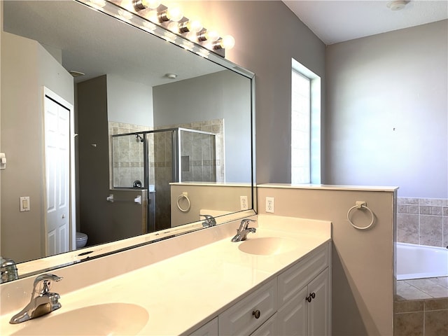 full bathroom with toilet, vanity, and separate shower and tub