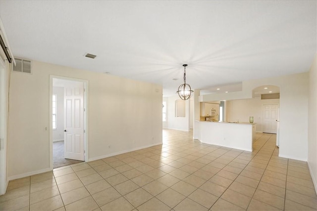 413 W Tangerine Sq SW, Vero Beach, FL 32968 - unfurnished living room with light tile patterned floors, a chandelier, arched walkways, and recessed lighting