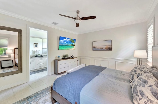 5950 Bella Rosa Ln, Vero Beach, FL 32966 - bedroom featuring crown molding, light tile patterned floors, connected bathroom, ceiling fan, and wainscoting
