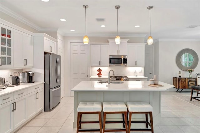 5950 Bella Rosa Ln, Vero Beach, FL 32966 - kitchen with stainless steel appliances, tasteful backsplash, light countertops, light tile patterned floors, and white cabinets