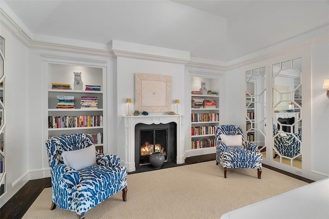 living area with ornamental molding, dark hardwood / wood-style flooring, and built in shelves