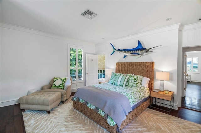 bedroom with wood-type flooring and ornamental molding