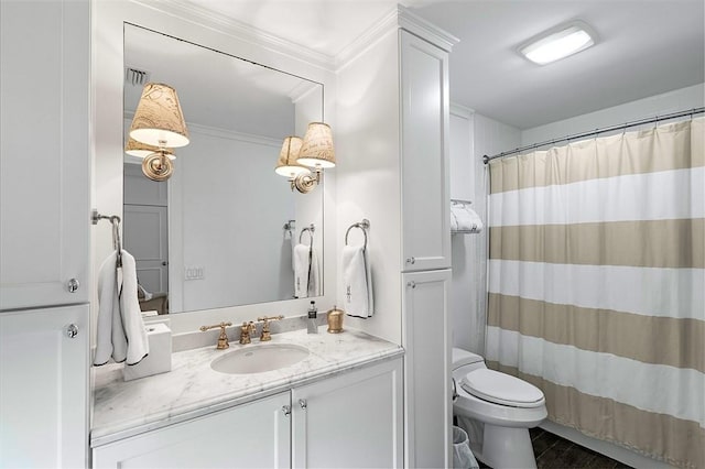 bathroom featuring vanity, crown molding, toilet, and walk in shower