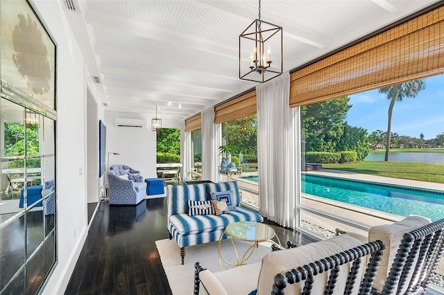 sunroom / solarium featuring beamed ceiling, a water view, a notable chandelier, and a wall unit AC