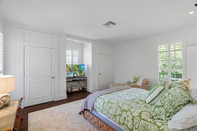 bedroom with dark wood-type flooring and ornamental molding