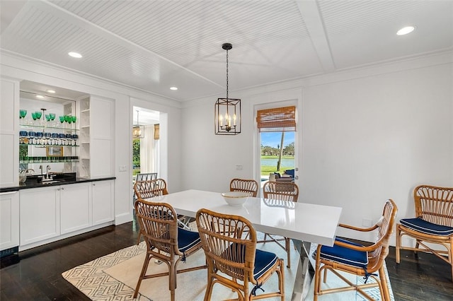 dining room featuring crown molding, dark wood-type flooring, and wet bar