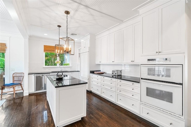 kitchen featuring stainless steel dishwasher, white double oven, a kitchen island, pendant lighting, and white cabinets