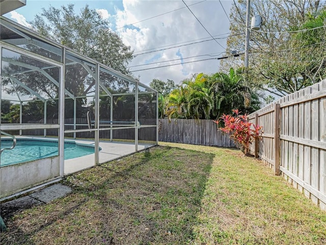 view of yard featuring a fenced in pool, a patio, and glass enclosure