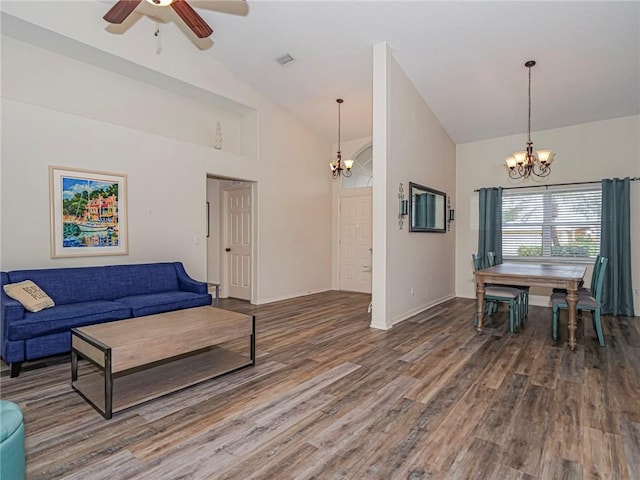 living room featuring ceiling fan with notable chandelier, dark wood-type flooring, and high vaulted ceiling