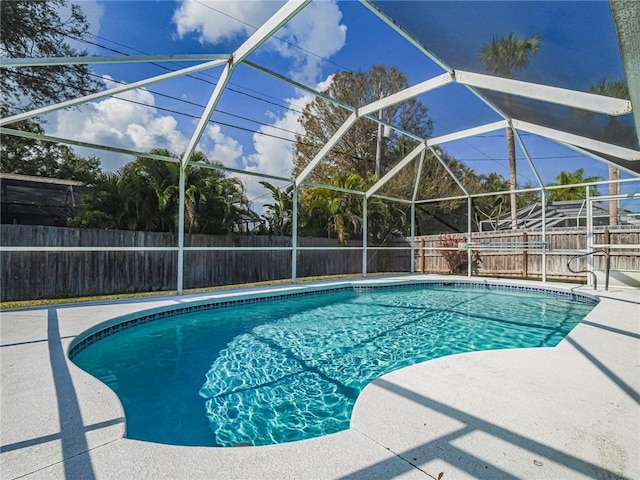 view of swimming pool featuring a lanai and a patio area