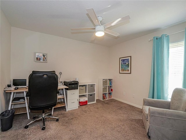 carpeted office space featuring ceiling fan