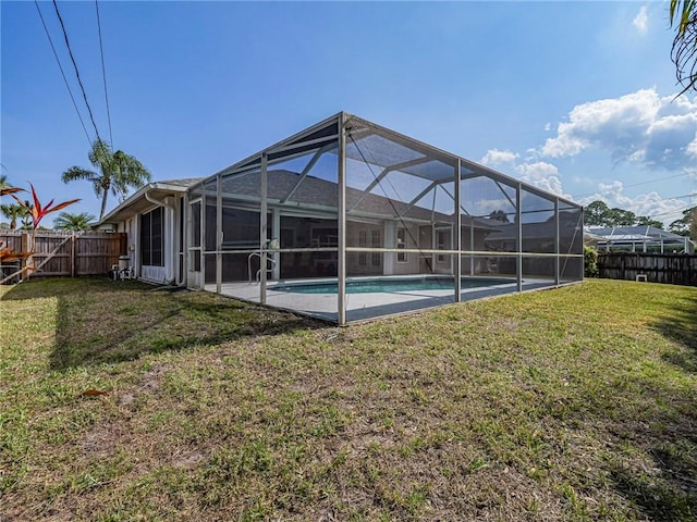 back of property with a fenced in pool, a lanai, and a yard