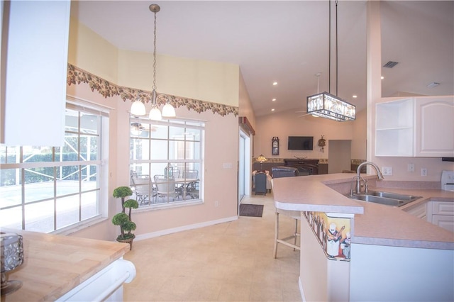 1018 Persian Ln, Sebastian, FL 32958 - kitchen featuring a chandelier, white cabinets, light countertops, pendant lighting, and a peninsula