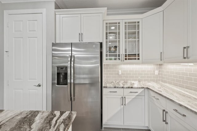 kitchen featuring white cabinets, ornamental molding, light stone counters, and stainless steel fridge with ice dispenser