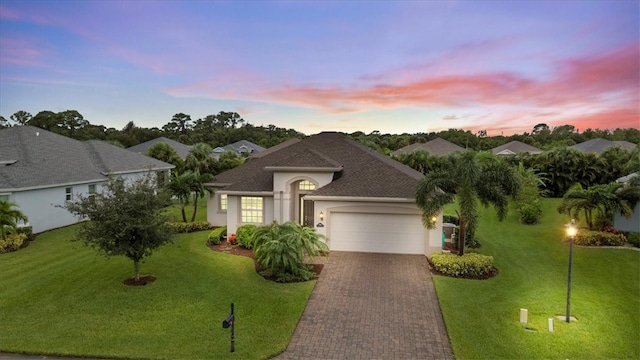 view of front of home with a garage and a yard