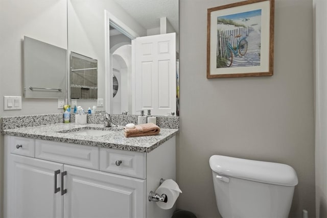 bathroom featuring vanity, toilet, and a textured ceiling