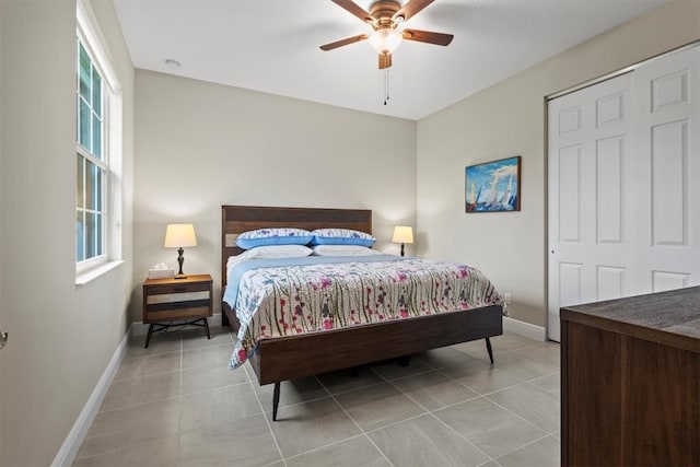 bedroom with light tile patterned flooring, ceiling fan, and a closet