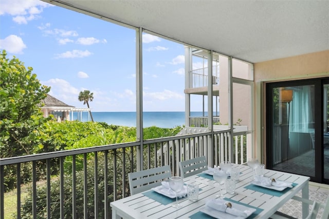 unfurnished sunroom featuring a water view