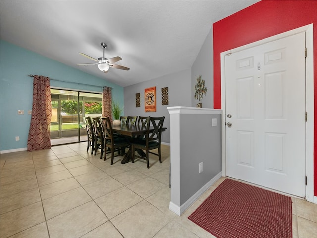 tiled dining room featuring ceiling fan and vaulted ceiling