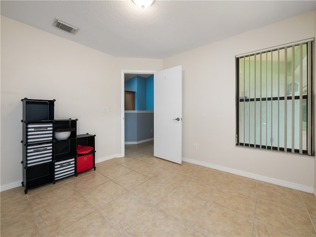 tiled office space featuring a textured ceiling