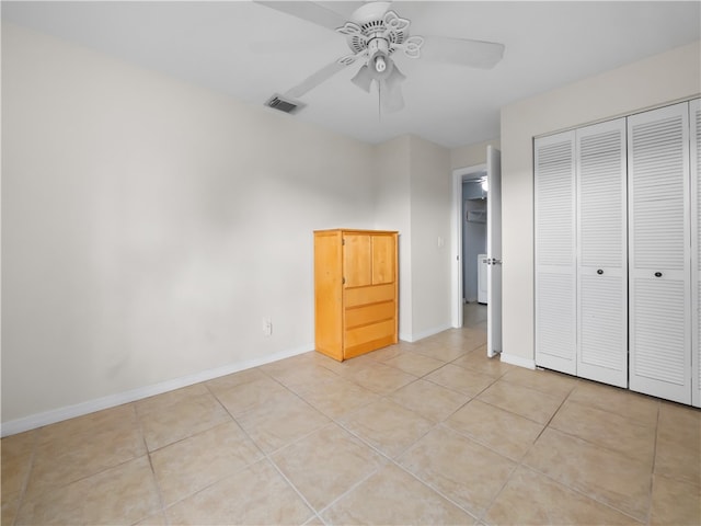 unfurnished bedroom featuring a closet, light tile patterned floors, and ceiling fan