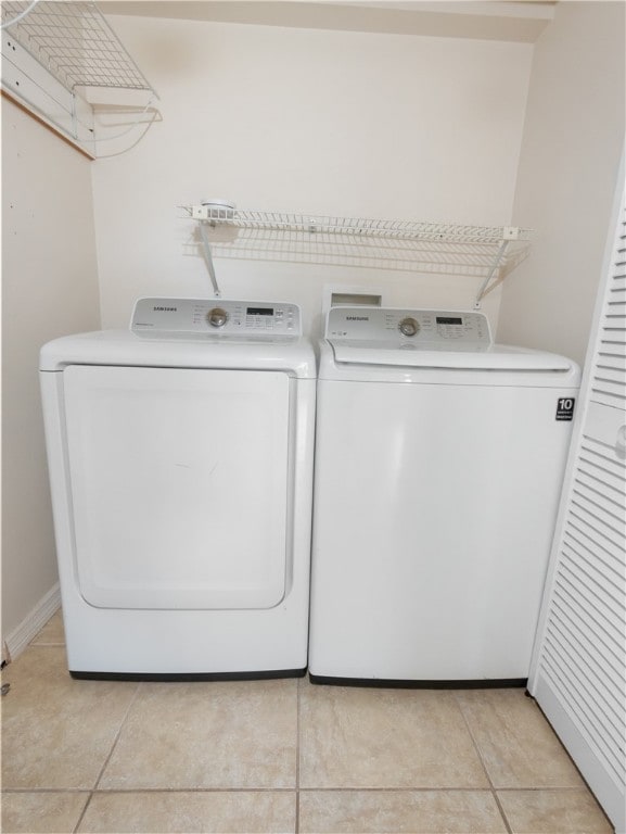 laundry room with light tile patterned floors and separate washer and dryer