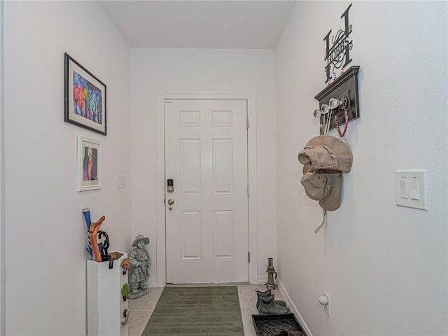 doorway featuring baseboards and light tile patterned floors