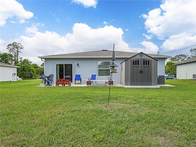 rear view of house with an outdoor structure, a lawn, a storage shed, and stucco siding