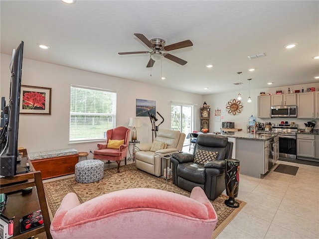 living area with light tile patterned floors, a ceiling fan, visible vents, and recessed lighting