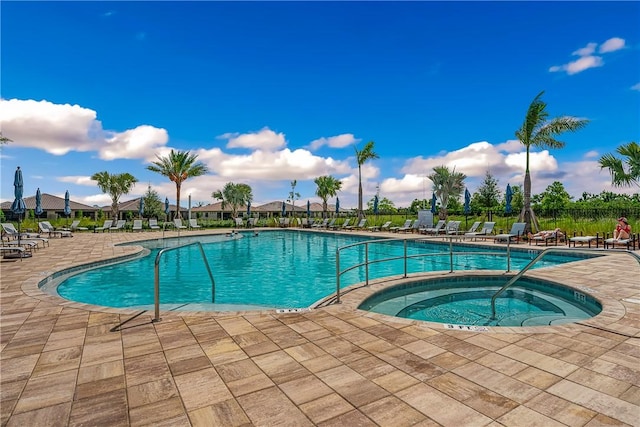 view of pool featuring a hot tub and a patio area