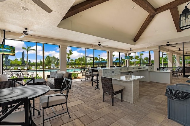 view of patio / terrace with a water view, exterior bar, and ceiling fan