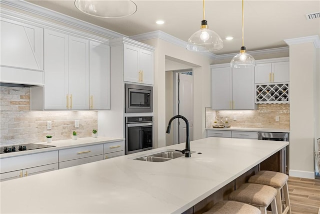 kitchen with ornamental molding, stainless steel appliances, sink, and white cabinets