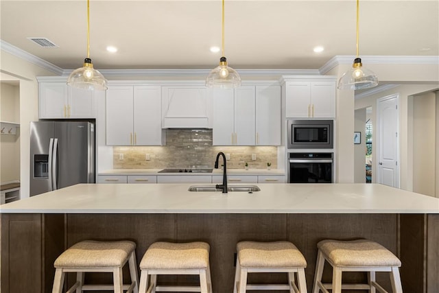 kitchen featuring sink, white cabinetry, hanging light fixtures, a large island with sink, and appliances with stainless steel finishes