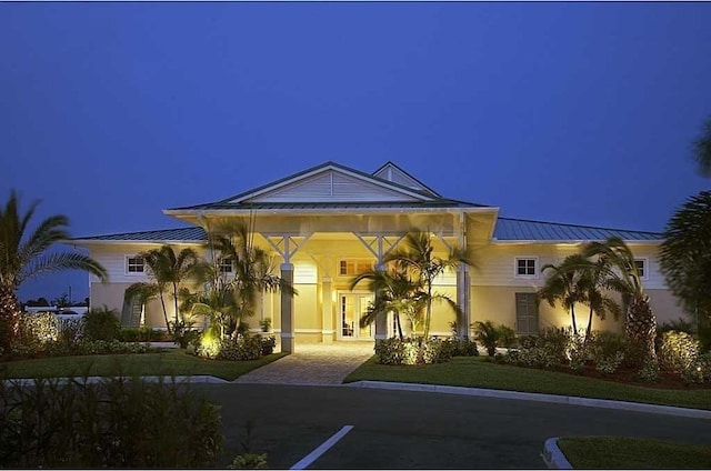 1370 Bunker Ct, Vero Beach, FL 32966 - view of front of house with a standing seam roof, stucco siding, a metal roof, and a yard