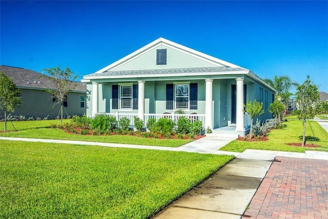1370 Bunker Ct, Vero Beach, FL 32966 - greek revival inspired property featuring a porch, stucco siding, a front yard, and roof with shingles