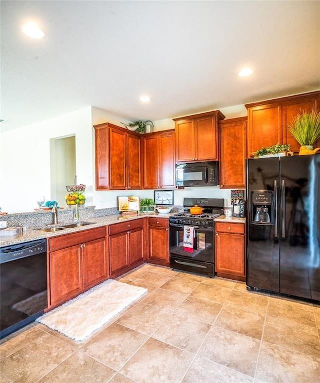 1370 Bunker Ct, Vero Beach, FL 32966 - kitchen with black appliances, light stone counters, recessed lighting, and brown cabinets